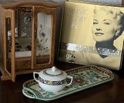 Holzvitrine mit Schmuck und einer dekorativen Schale auf einem Tablett neben einer Schallplatte mit dem Titel 'Music of My Life'.